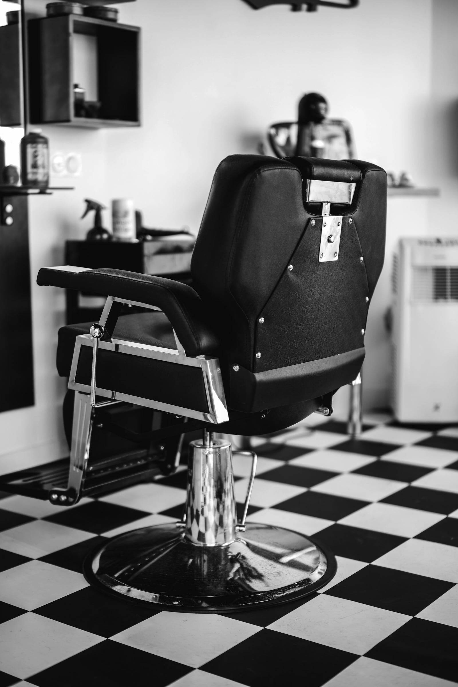 Barberstuhl auf einem schwarzweiss karierten Boden
