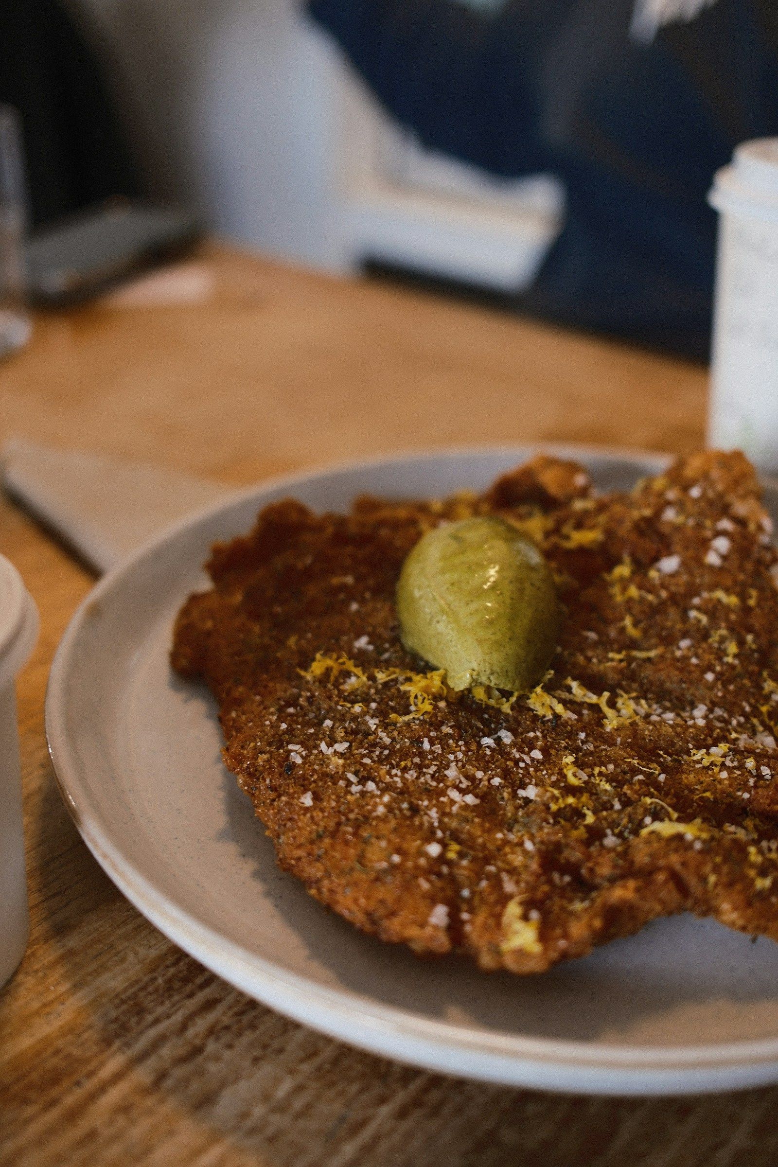 Paniertes Schnitzel mit Kräuterbutter auf einem hellen Teller