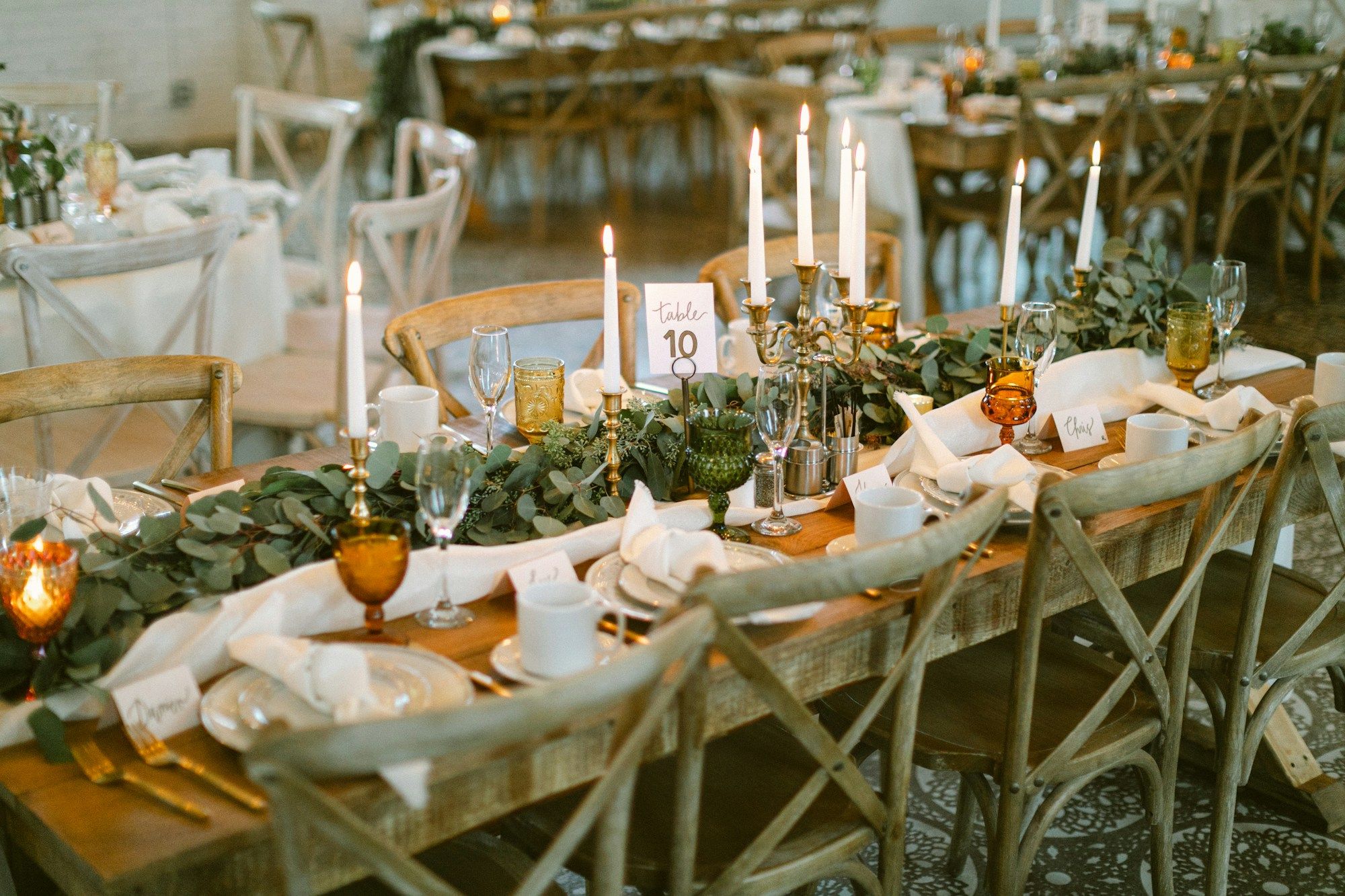 Lange Holztafel mit Gläsern und Kerzen in einer gemütlichen Stube