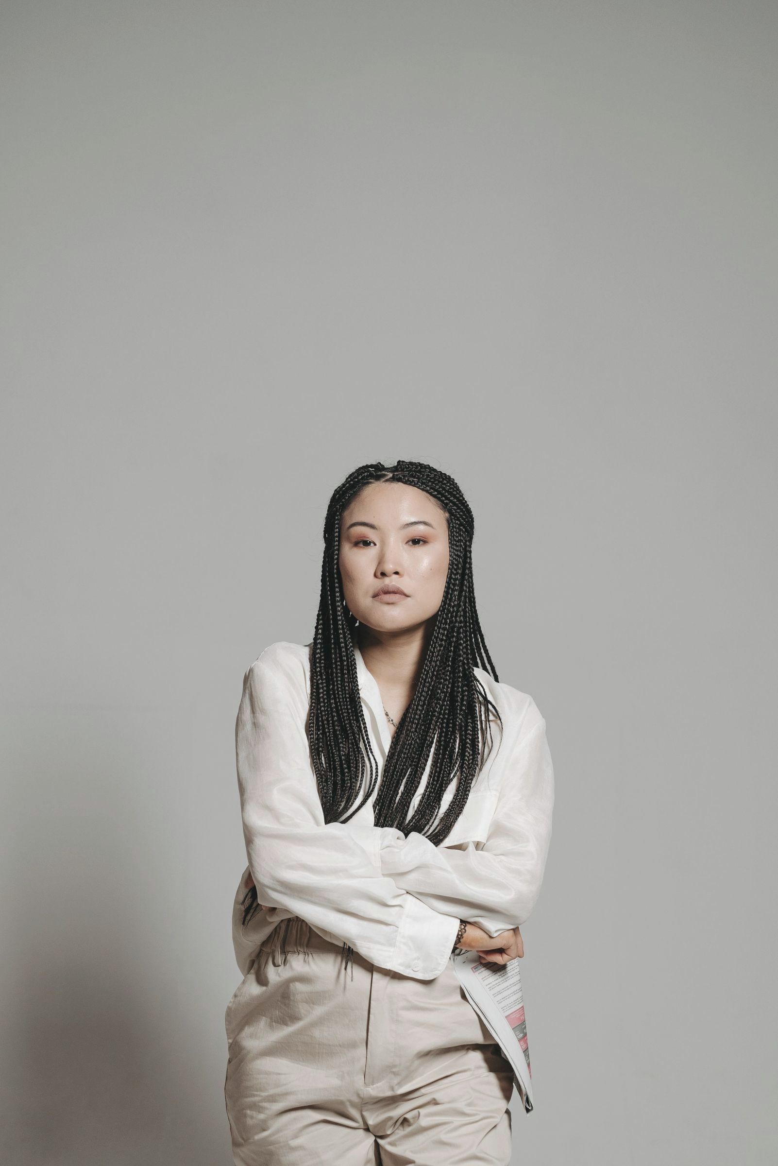 Porträt von Mei Lin Haller mit verschränkten Armen vor einer hellen Wand